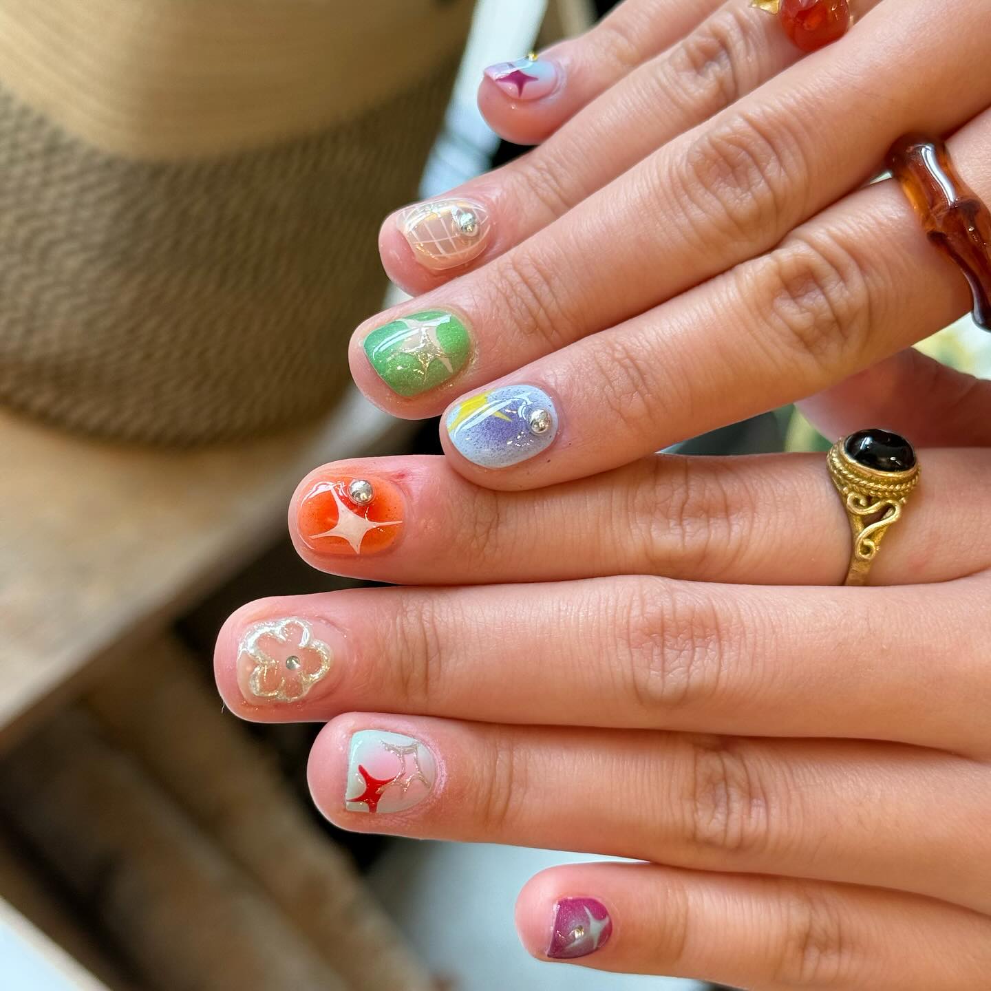 Short colorful nails with sparkles and chrome studs